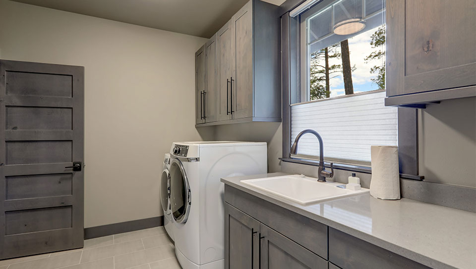 Beautiful-laundry-room-with-rish-wooden-doors-and-white-washer-and-dryer.